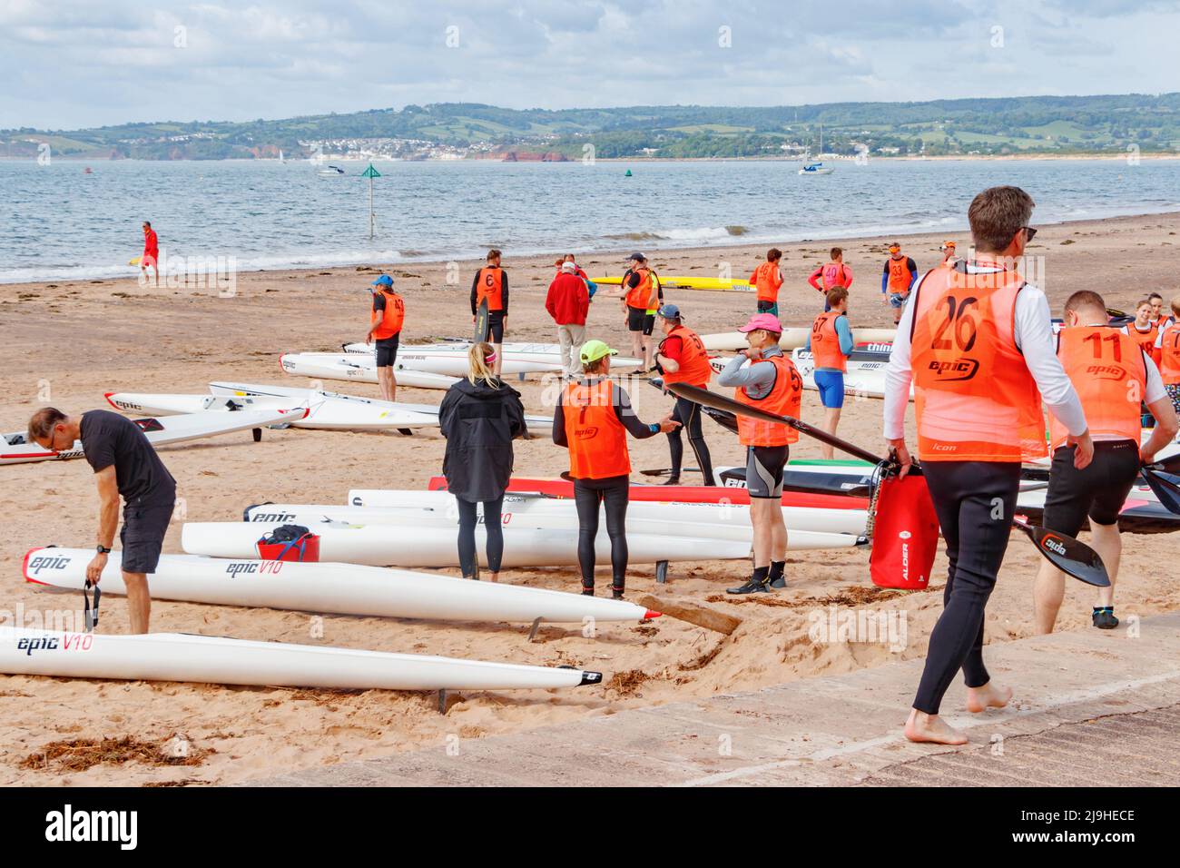 Canoës et canoéistes se préparant à Epic Bay Ocean Race 2022 Exmouth Beach Rescue Club, dans la mer à Exmouth Devon UK Banque D'Images