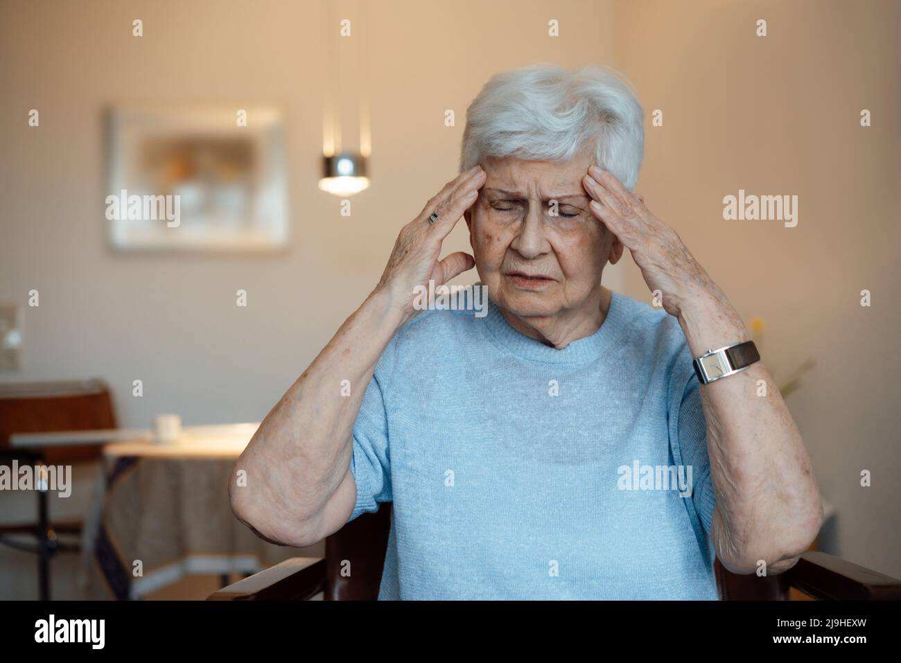 Femme âgée fatiguée aux prises avec des maux de tête à la maison Banque D'Images
