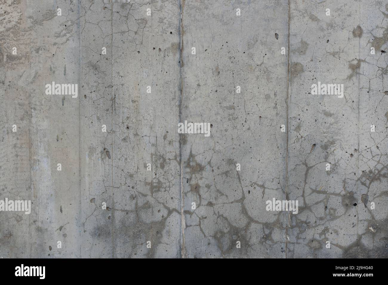 Texture en béton renforcé avec des zones couvertes de petites fissures et de petites taches. Surface de béton armé ancien et sale avec traces de coffrage. Banque D'Images