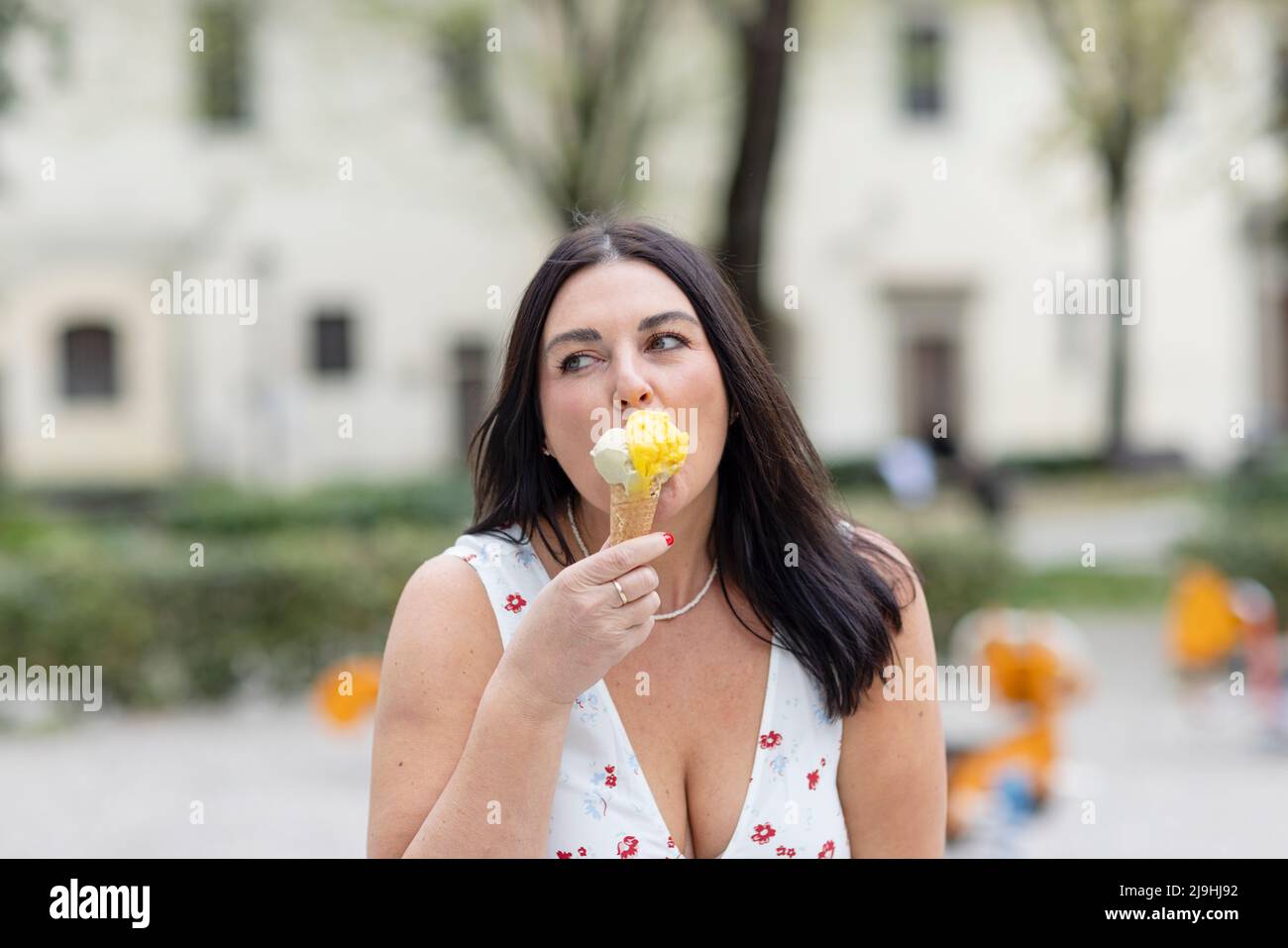 Belle femme avec de longs cheveux manger de la glace Banque D'Images