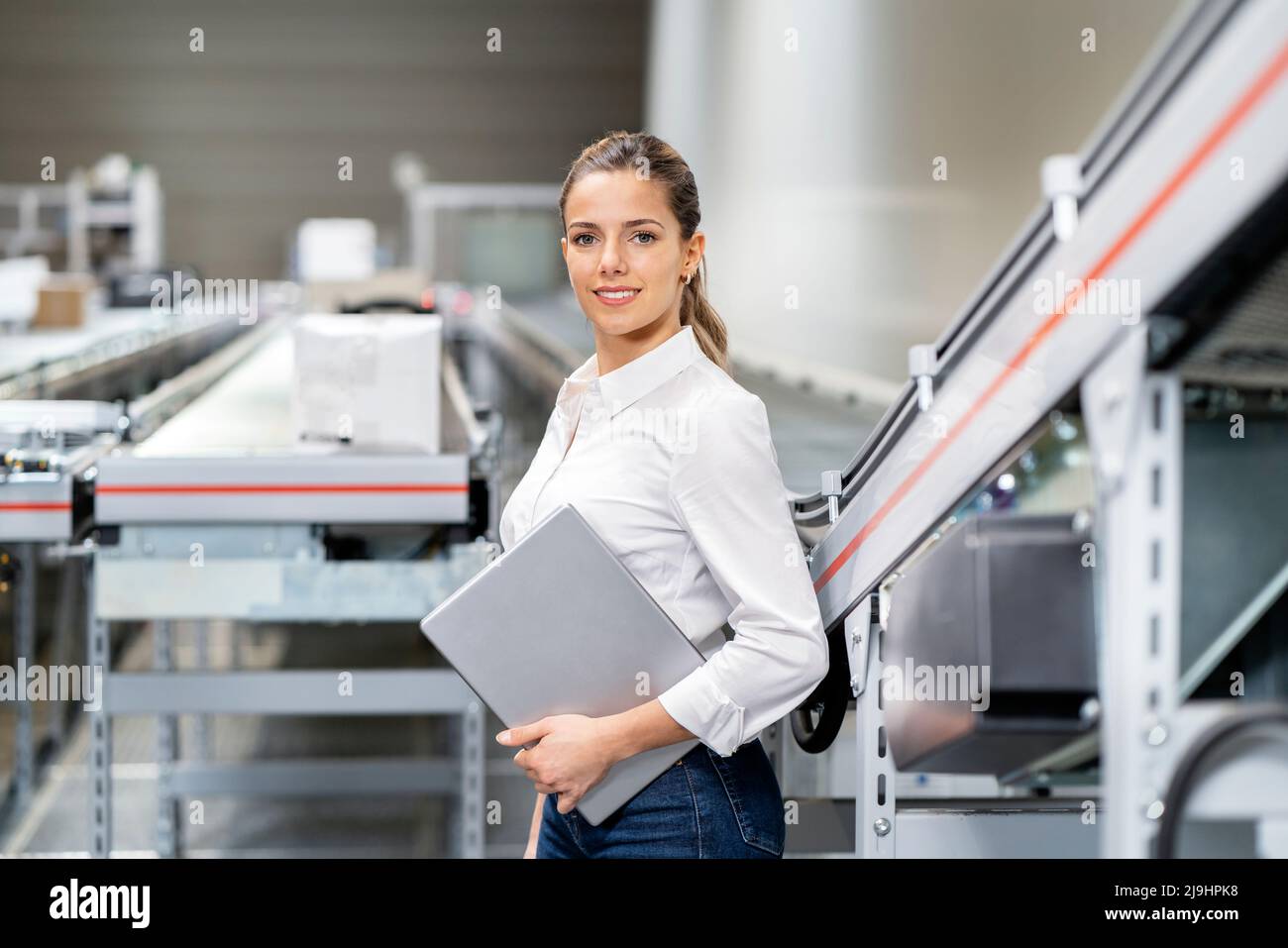 Jeune femme d'affaires confiante avec un PC tablette dans un entrepôt Banque D'Images