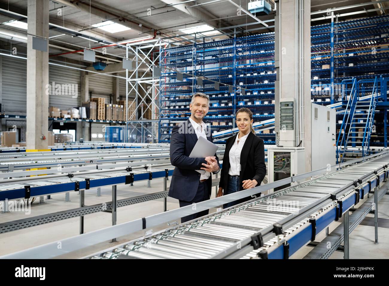 Des employés professionnels en toute confiance grâce à un tapis convoyeur dans un entrepôt Banque D'Images