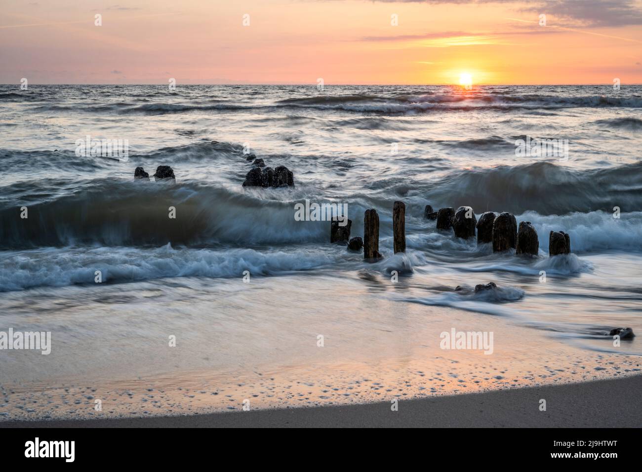 Allemagne, Schleswig-Holstein, Rantum, Beach groyne au coucher du soleil avec ligne d'horizon claire au-dessus de la mer du Nord en arrière-plan Banque D'Images