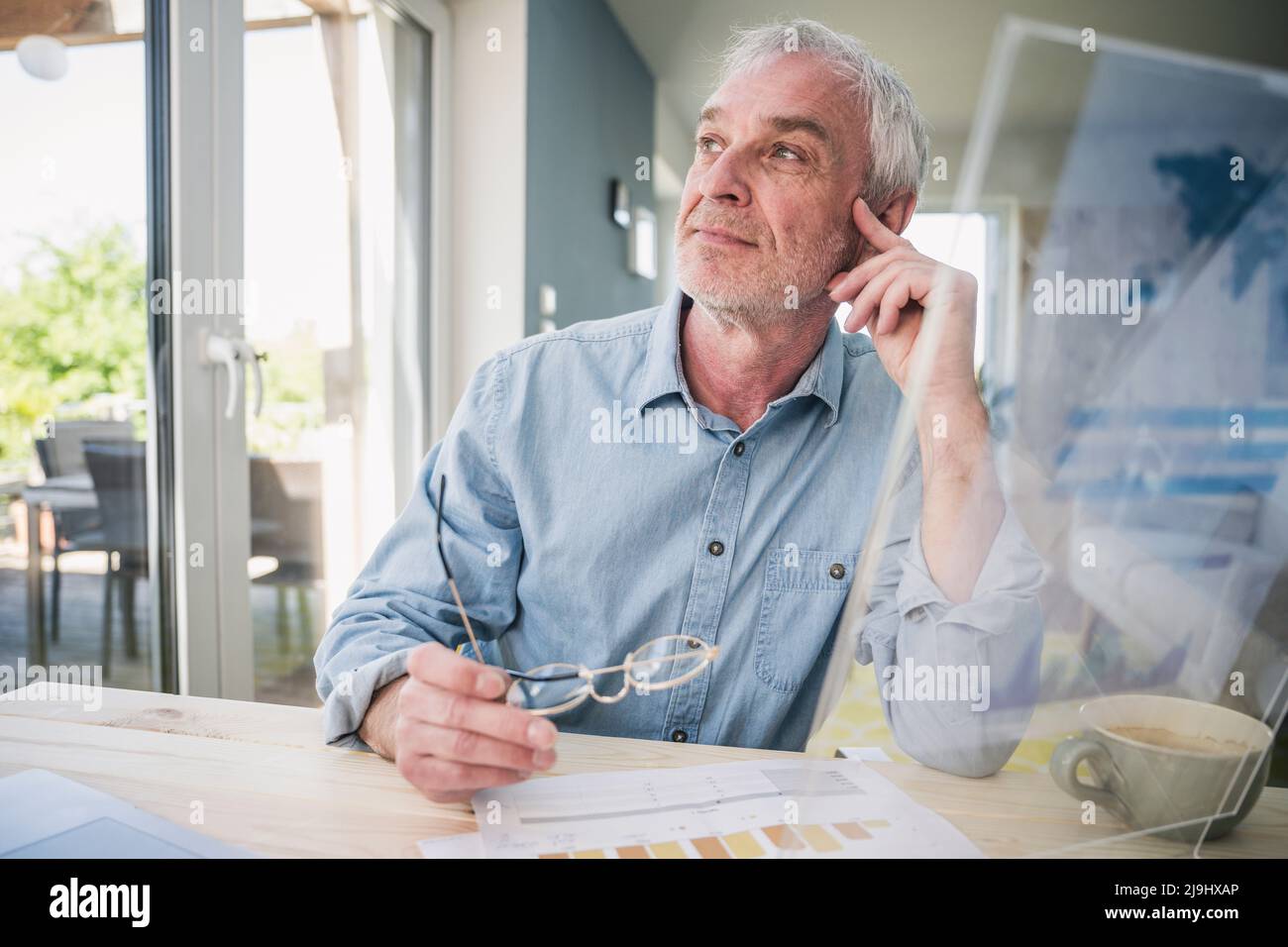 Indépendant expérimenté et attentif avec écran transparent assis à table Banque D'Images