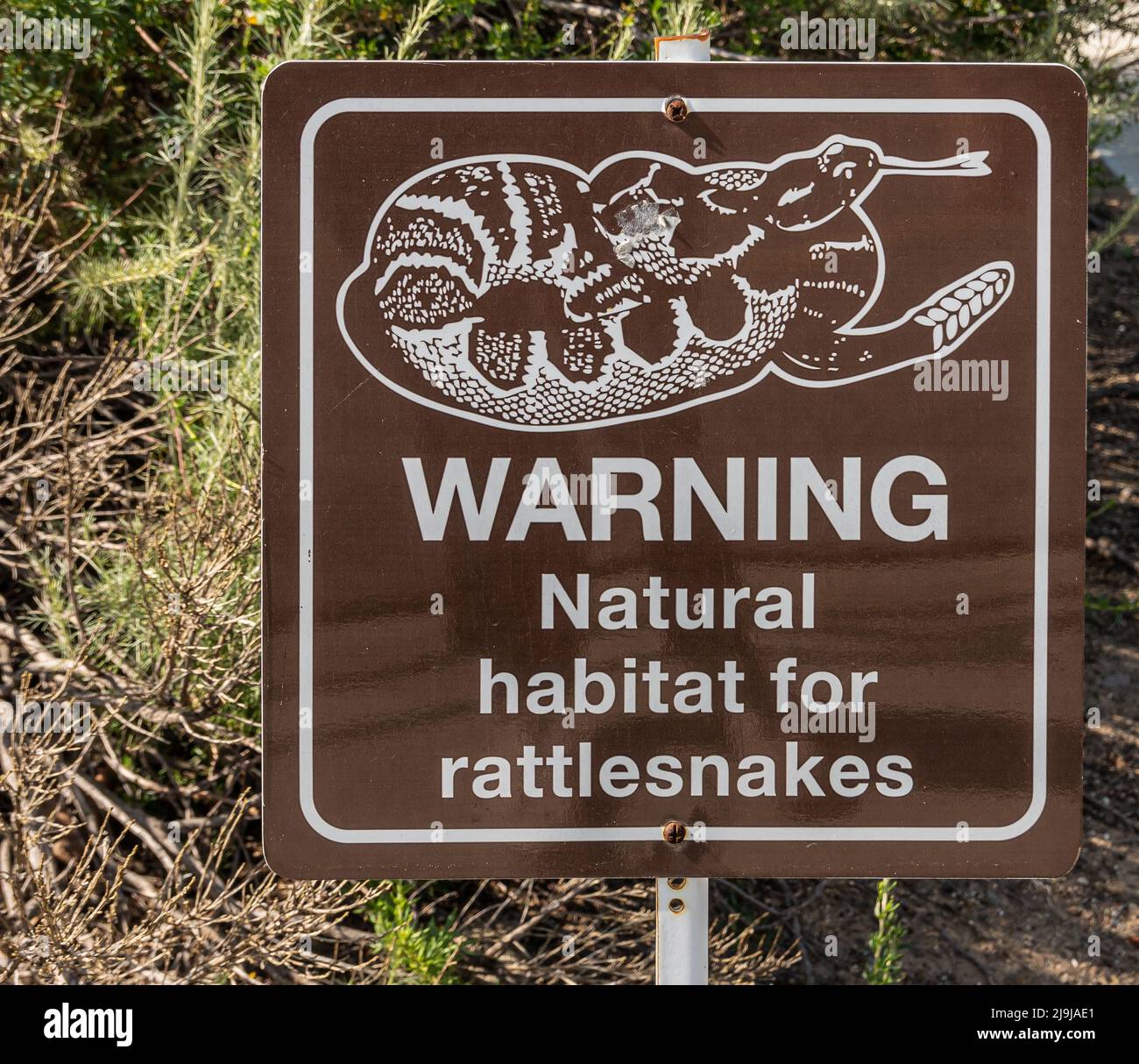 Simi Valley, Californie, États-Unis - 27 avril 2022 : gros plan du panneau d'avertissement sur la présence de crotales dans leur habitat naturel. Image et lettre blanches Banque D'Images