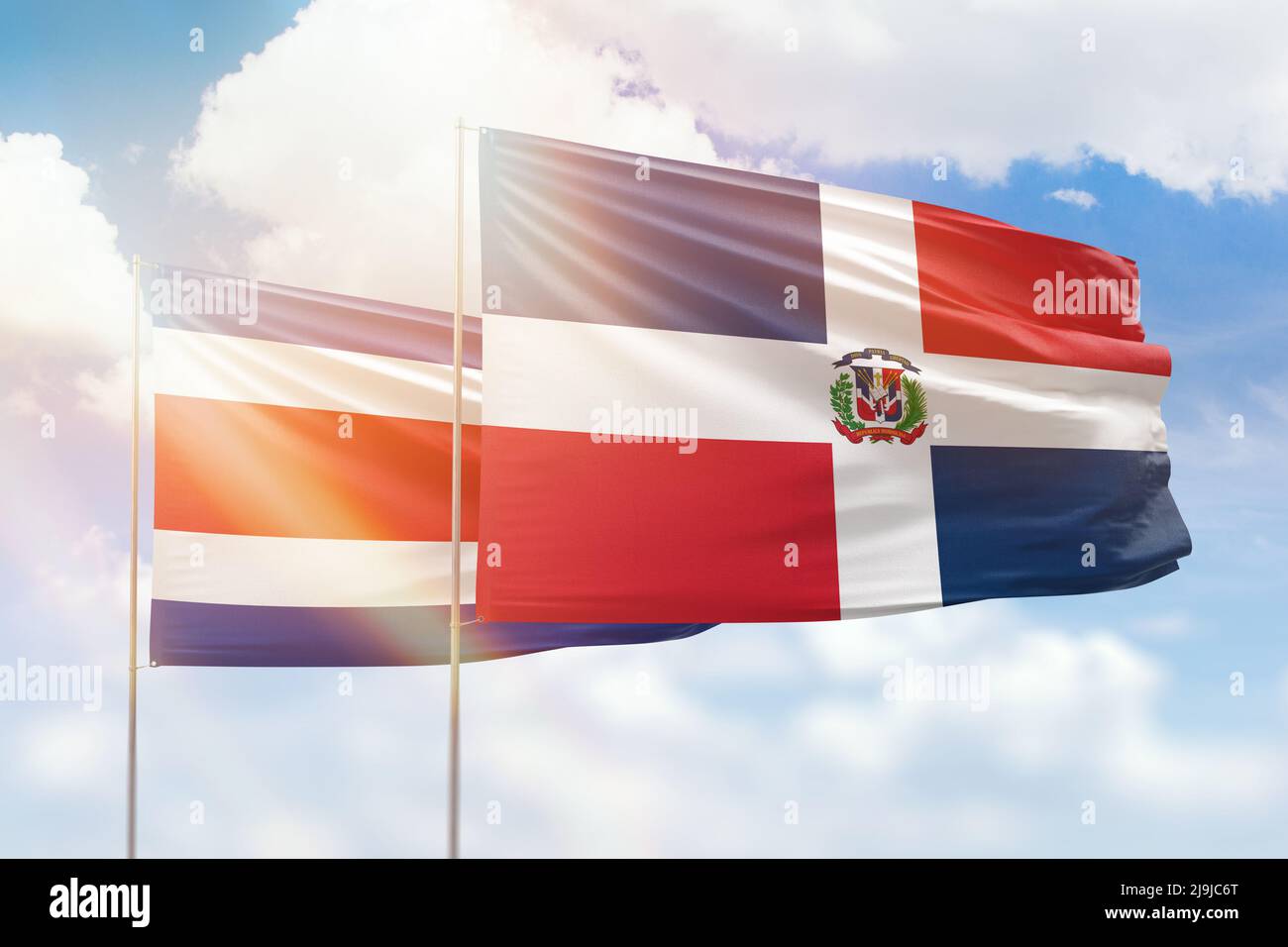 Ciel bleu ensoleillé et drapeaux de la république dominicaine et du costa rica Banque D'Images