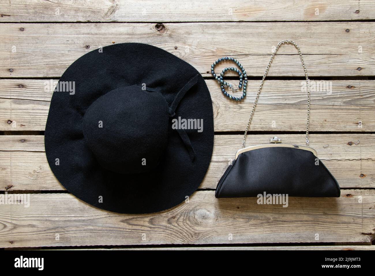 Chapeau noir pour femmes et sac de soirée noir et plusieurs perles sur une  table en bois, mode et tendance, beauté et accessoires Photo Stock - Alamy