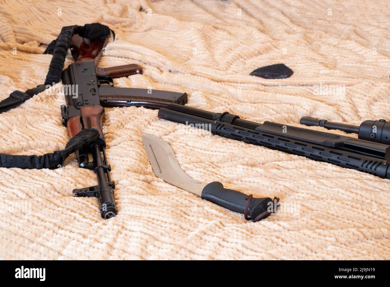 Une arme à feu et un couteau reposent sur un tissu, une arme militaire, une arme de soldat en guerre 2022 Banque D'Images