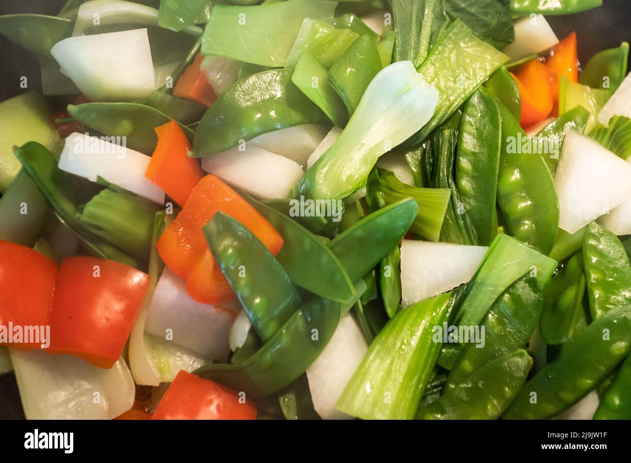 Rottweil, Allemagne. 23rd mai 2022. Les pois mange-tout, les poivrons rouges, le chou-rave et le pak choi sont cuits dans un wok. Crédit : Silas Stein/dpa/Alay Live News Banque D'Images