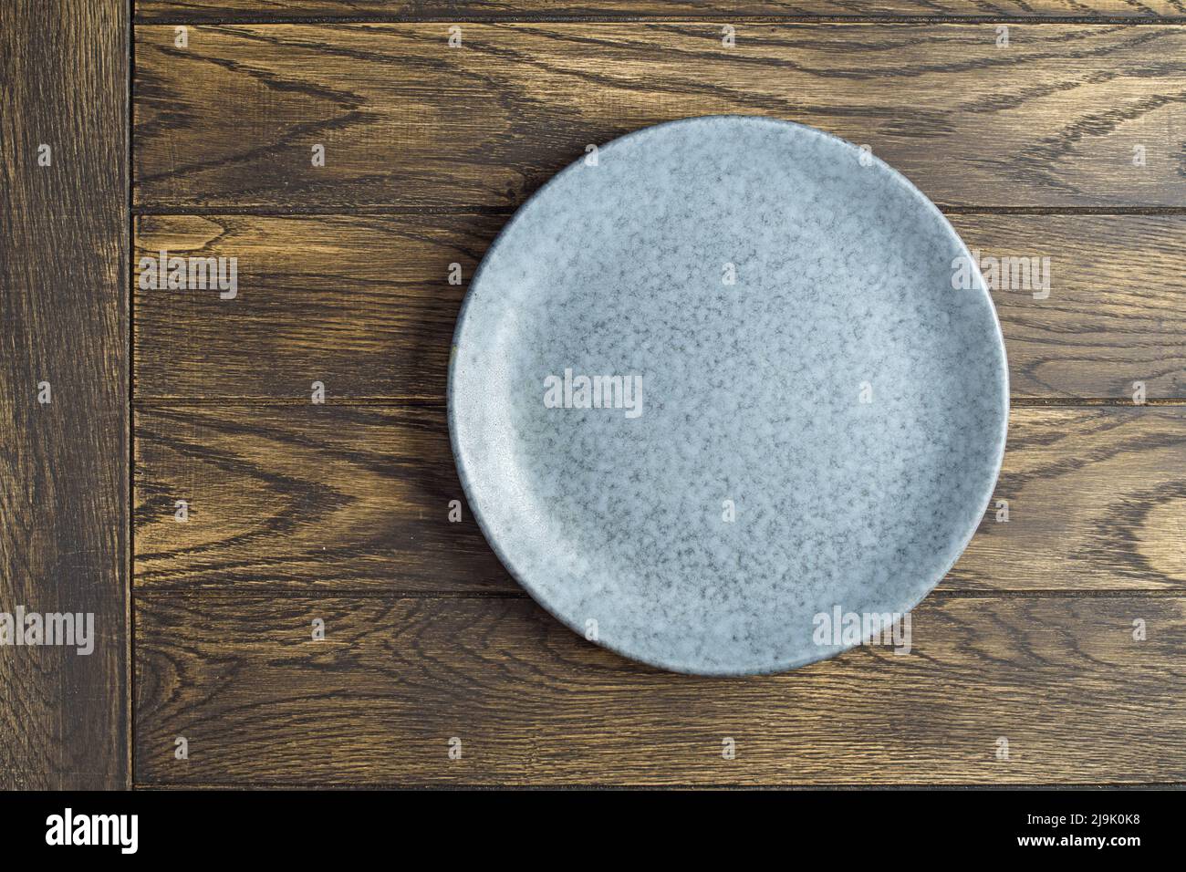 Vider la plaque bleuâtre sur une table en bois de chêne. Vue du dessus, avec espace de copie Banque D'Images