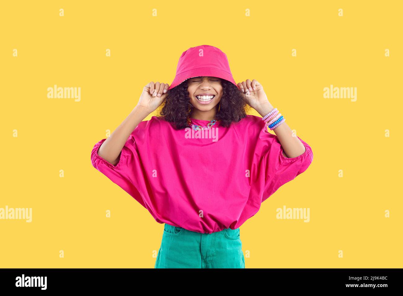 Happy Black girl dans un ensemble tendance et décontracté riant et s'amusant dans un studio de mode Banque D'Images