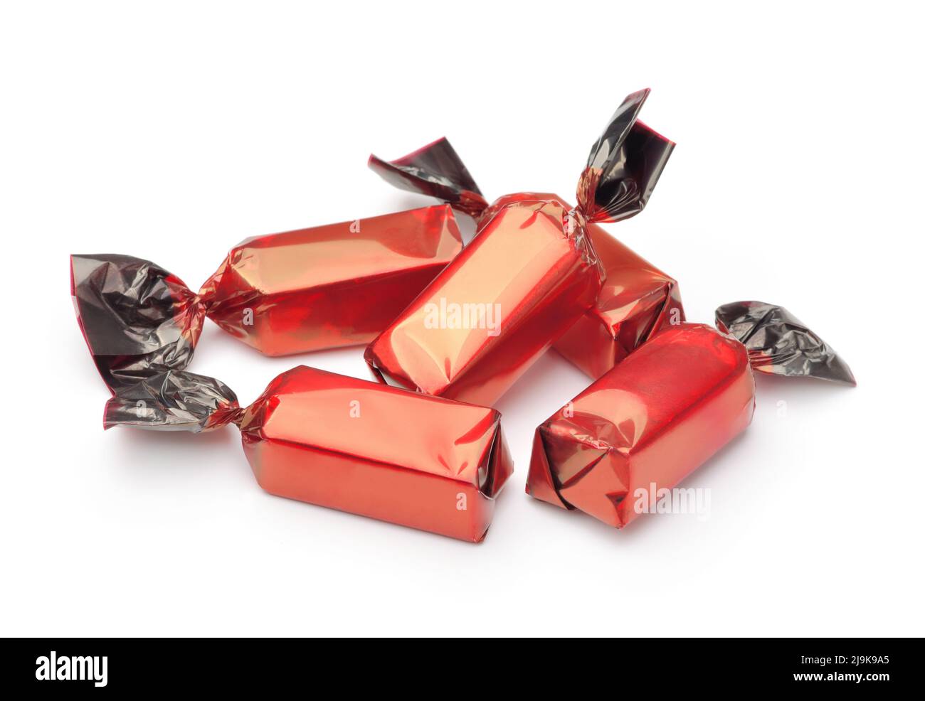 Groupe de bonbons au chocolat enveloppés dans des emballages rouges isolés sur du blanc Banque D'Images