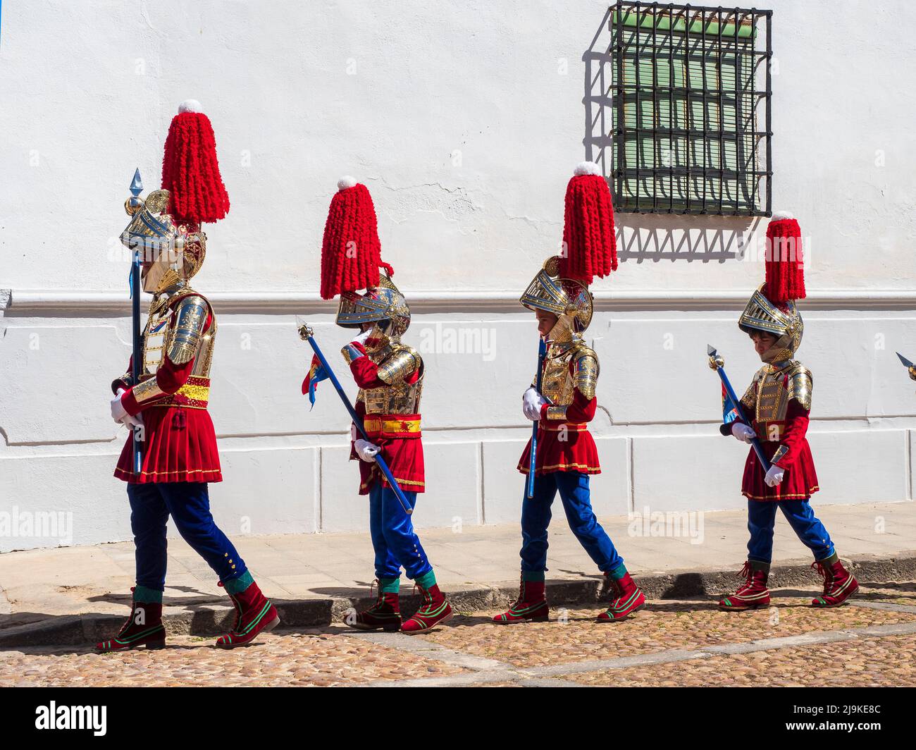 Quatre enfants de la Compagnie romaine d'Almagro se rendant à travers la Plaza Mayor vers le défilé du dimanche de Pâques le dimanche des palmiers. Banque D'Images