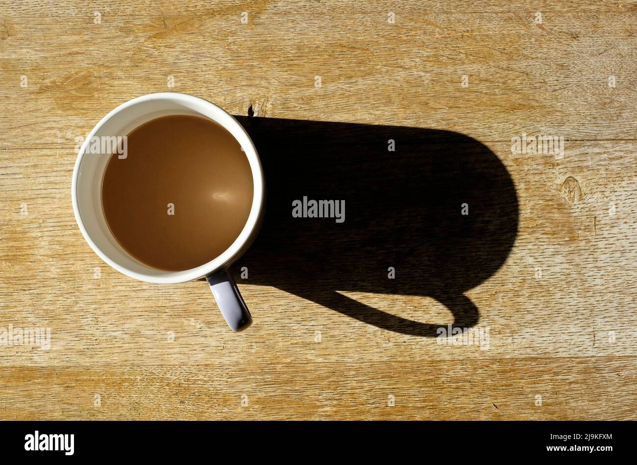 tasse de café sur table avec ombre longue Banque D'Images