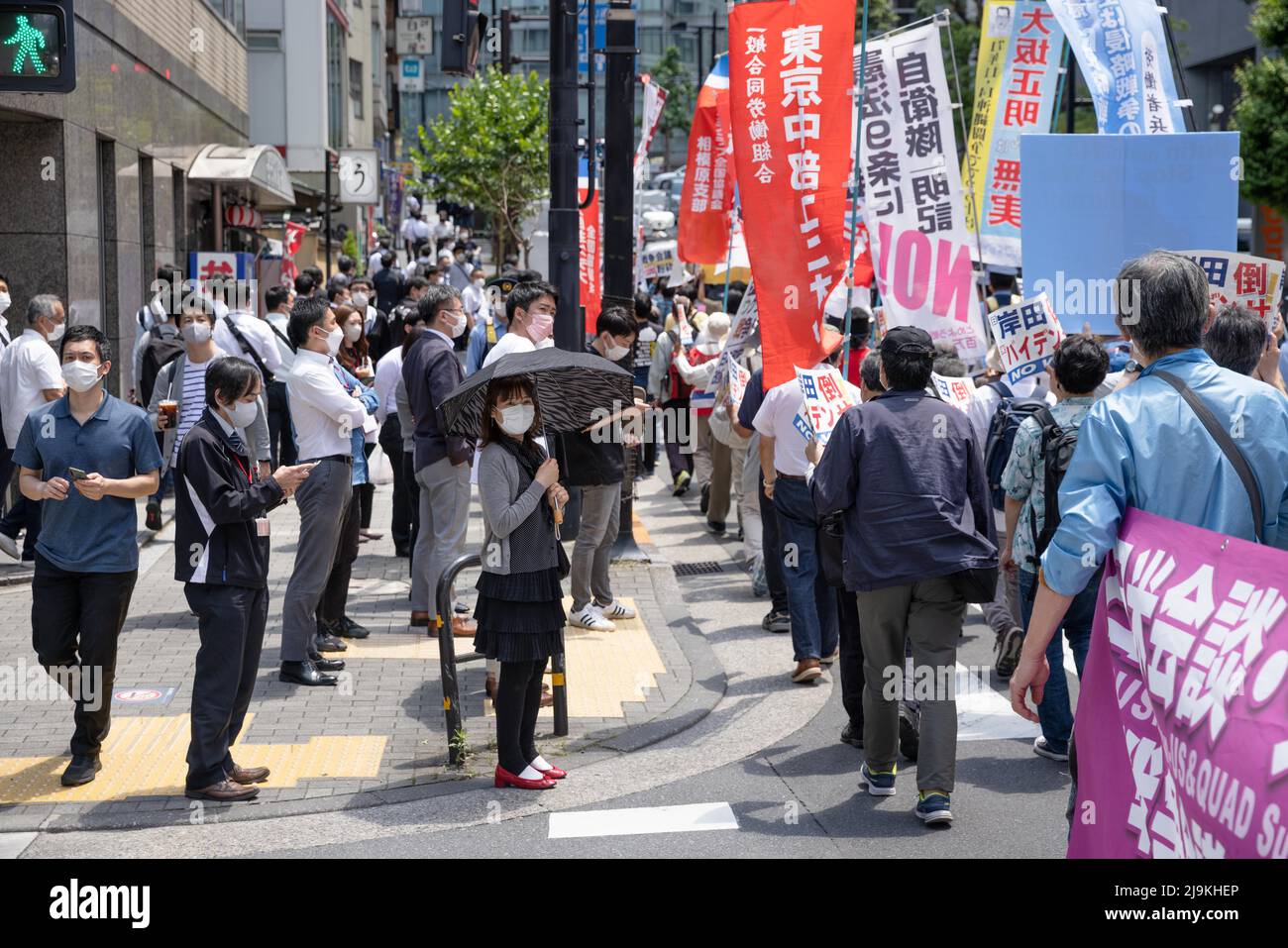 Tokyo, Japon. 24th mai 2022. Les spectateurs regardent des manifestants qui scandaient des slogans anti-gouvernementaux et exigeaient le « concassage » du Japon, de l'Australie, de l'Inde et des États-Unis (Quad) Réunion des dirigeants 2022. Un petit groupe d'environ 100 manifestants se sont rassemblés dans le centre de Tokyo pour protester contre la Réunion des dirigeants du Quad 2022 et pour exprimer leur opinion sur la guerre en cours en Ukraine critiquant la Russie, les États-Unis et l'OTAN. Ils ont également appelé le Premier ministre japonais Fumio Kishida à démissionner ainsi que le président américain Joe Biden. Crédit : SOPA Images Limited/Alamy Live News Banque D'Images