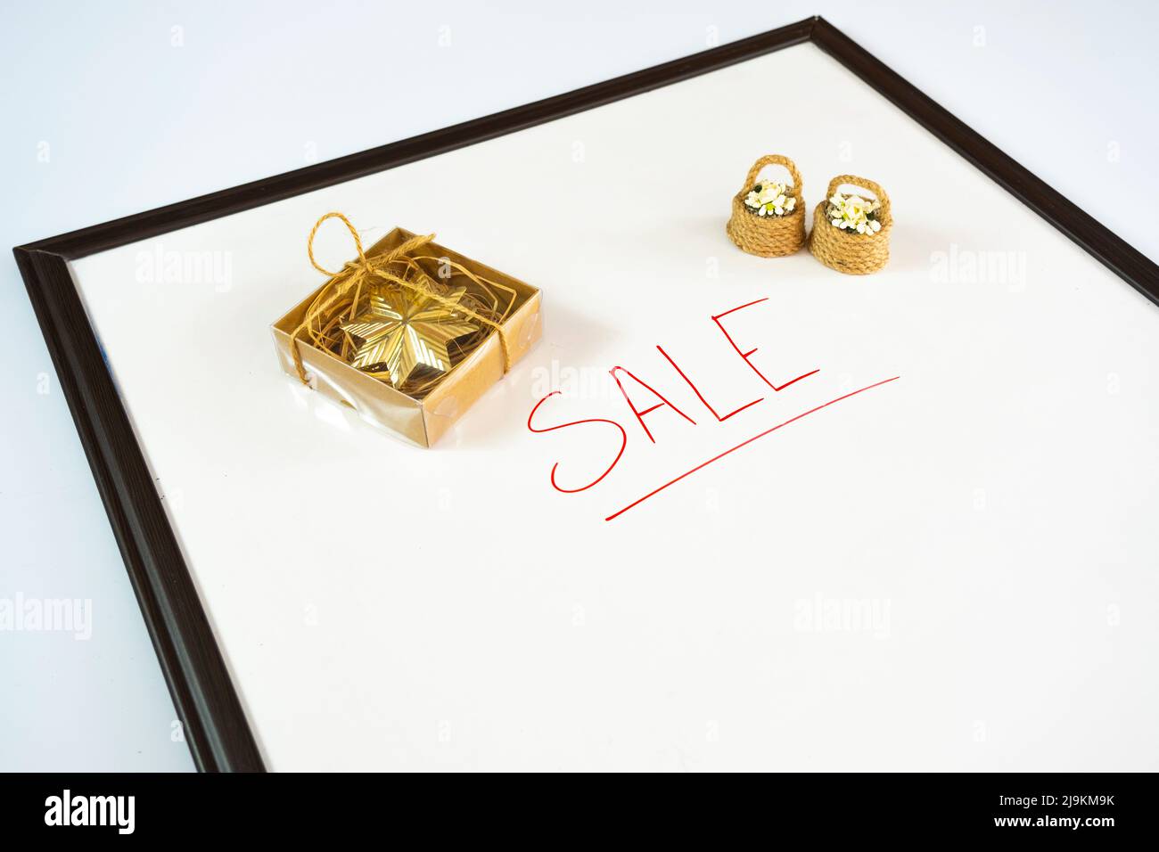 Texte de vente avec marqueur de couleur rouge et boîte cadeau sur un tableau blanc, idée de cadeau, concept d'achat, bannière publicitaire pour e-commerce, espace de copie Banque D'Images