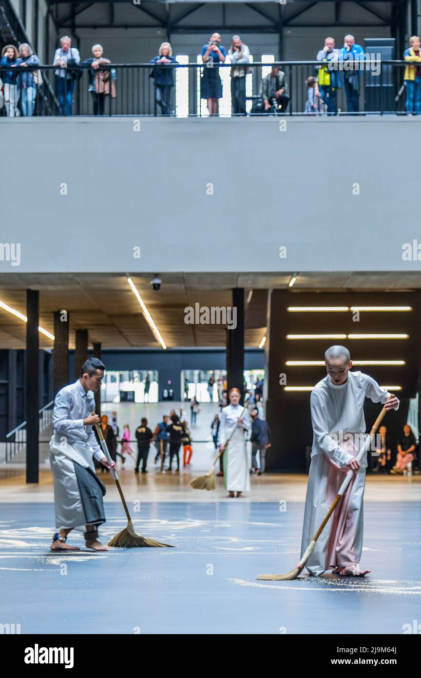 Londres, Royaume-Uni. 24 mai 2022. Tate Modern met en scène la première performance britannique de notre labyrinthe de l'artiste Lee Mingwei. Exécuté en continu du matin au soir dans la salle de turbine pendant trois semaines. Notre labyrinthe transforme le simple geste de balayage en une performance contemplative et gestuelle, apportant un sens du rituel dans la galerie. Deux danseurs avec des cloches attachées à leurs chevilles forment les grains en une série de chemins labyrinthiques. L'œuvre est inspirée par l'expérience de l'artiste de visiter des temples anciens dans la campagne du Myanmar, où les chemins menant des huttes aux temples sont balayés par volontaire Banque D'Images