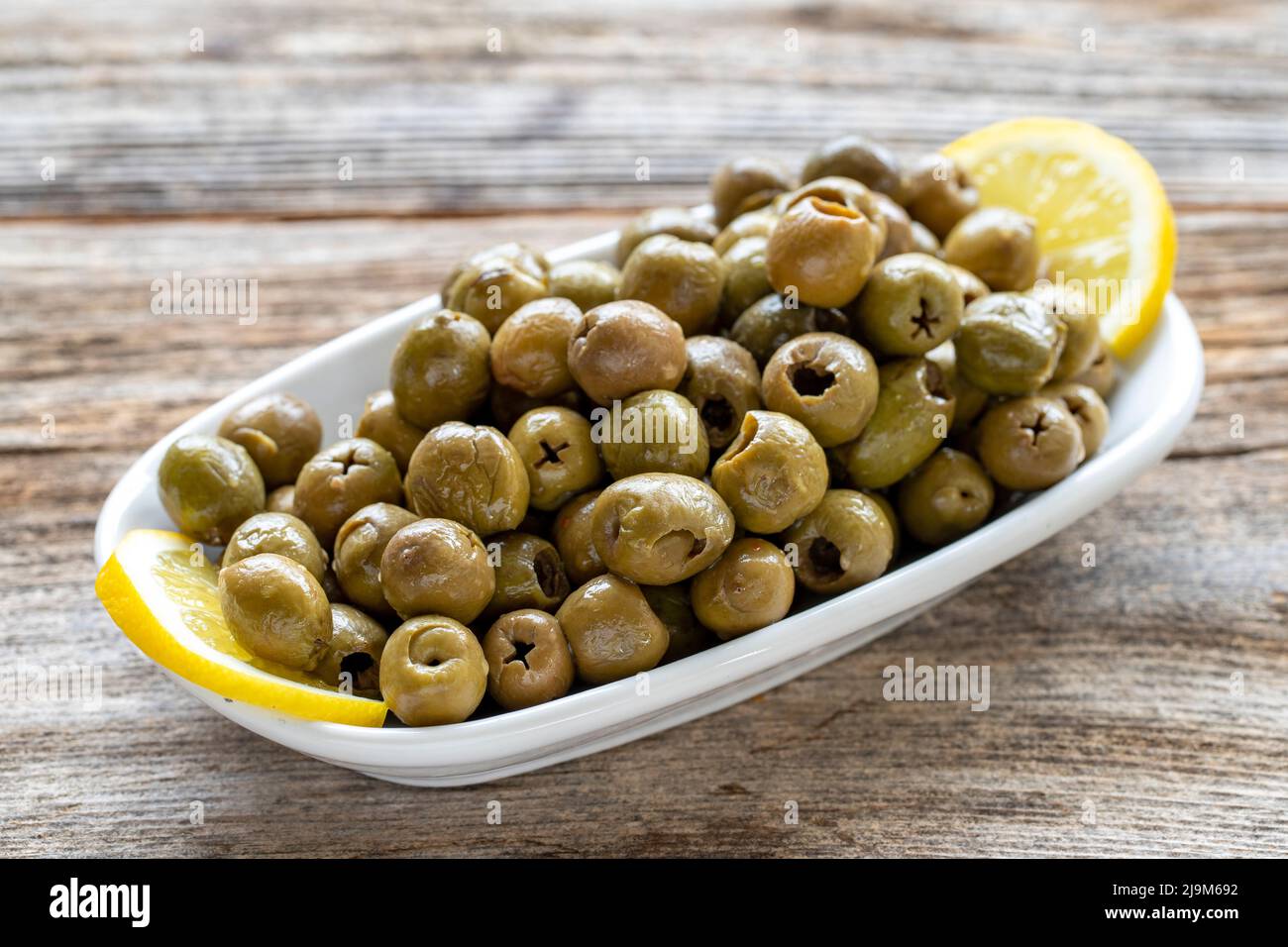 Olive verte. Olive naturelle sur fond de parquet. Alimentation saine. Gros plan Banque D'Images