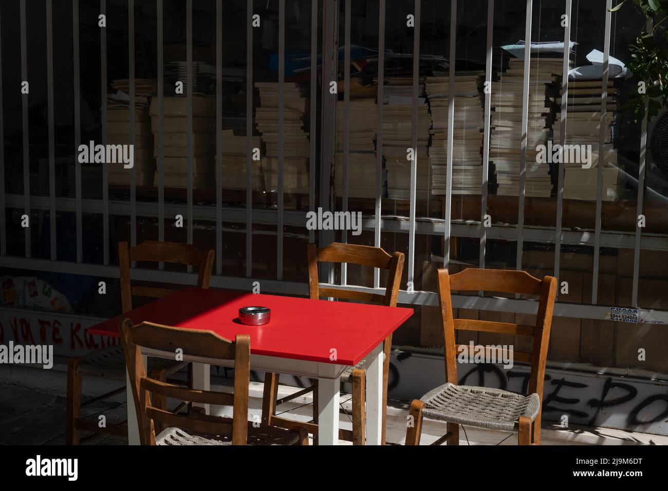 Une table et des chaises rouges sur le trottoir devant une librairie Banque D'Images