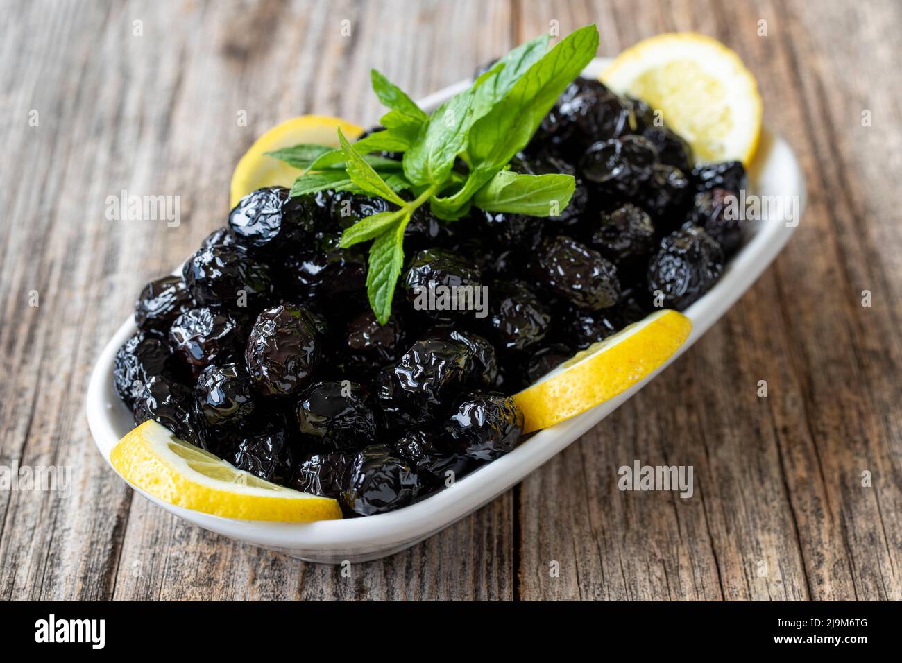 Olive noire. Olive noir naturel sur fond de parquet. Alimentation saine. Gros plan Banque D'Images