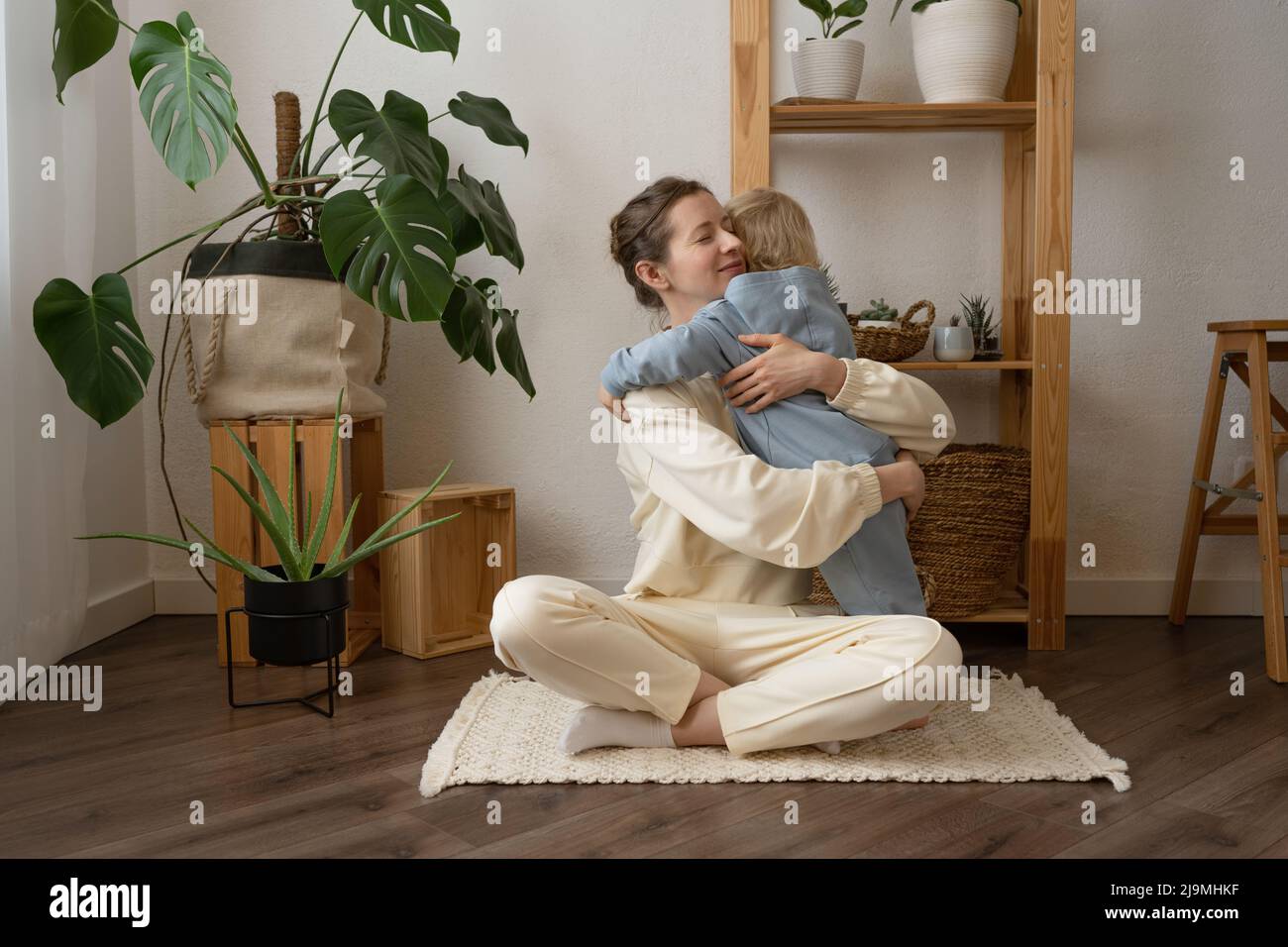 Crochez une femme adulte avec des cheveux ondulés en buvant un café savoureux tout en regardant vers l'avant dans la maison Banque D'Images