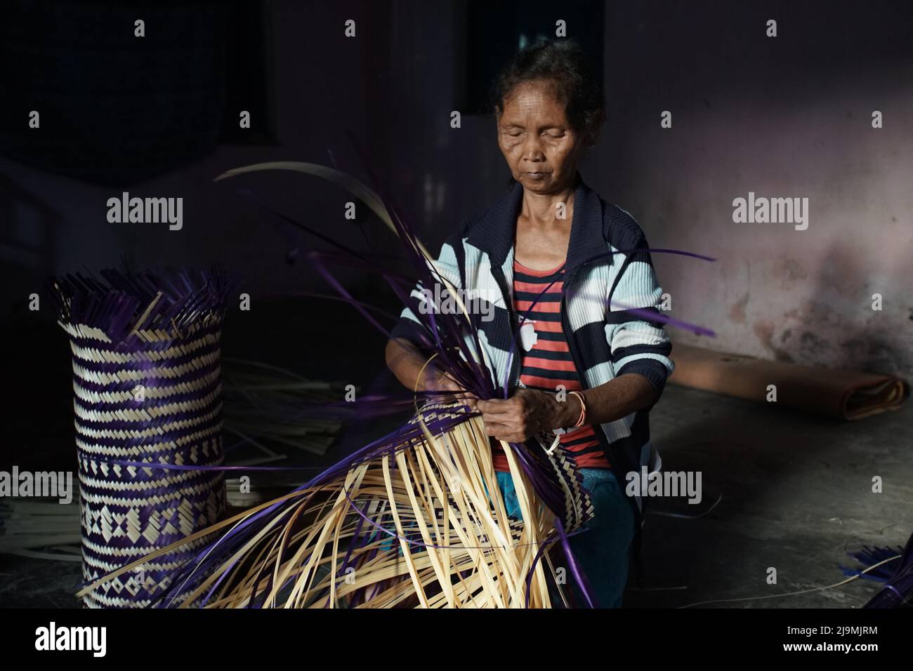 Une vieille femme qui vante du bambou pour faire un artisanat traditionnel ou un souvenir au village de Brajan, Sleman, Yogyakarta, Indonésie Banque D'Images