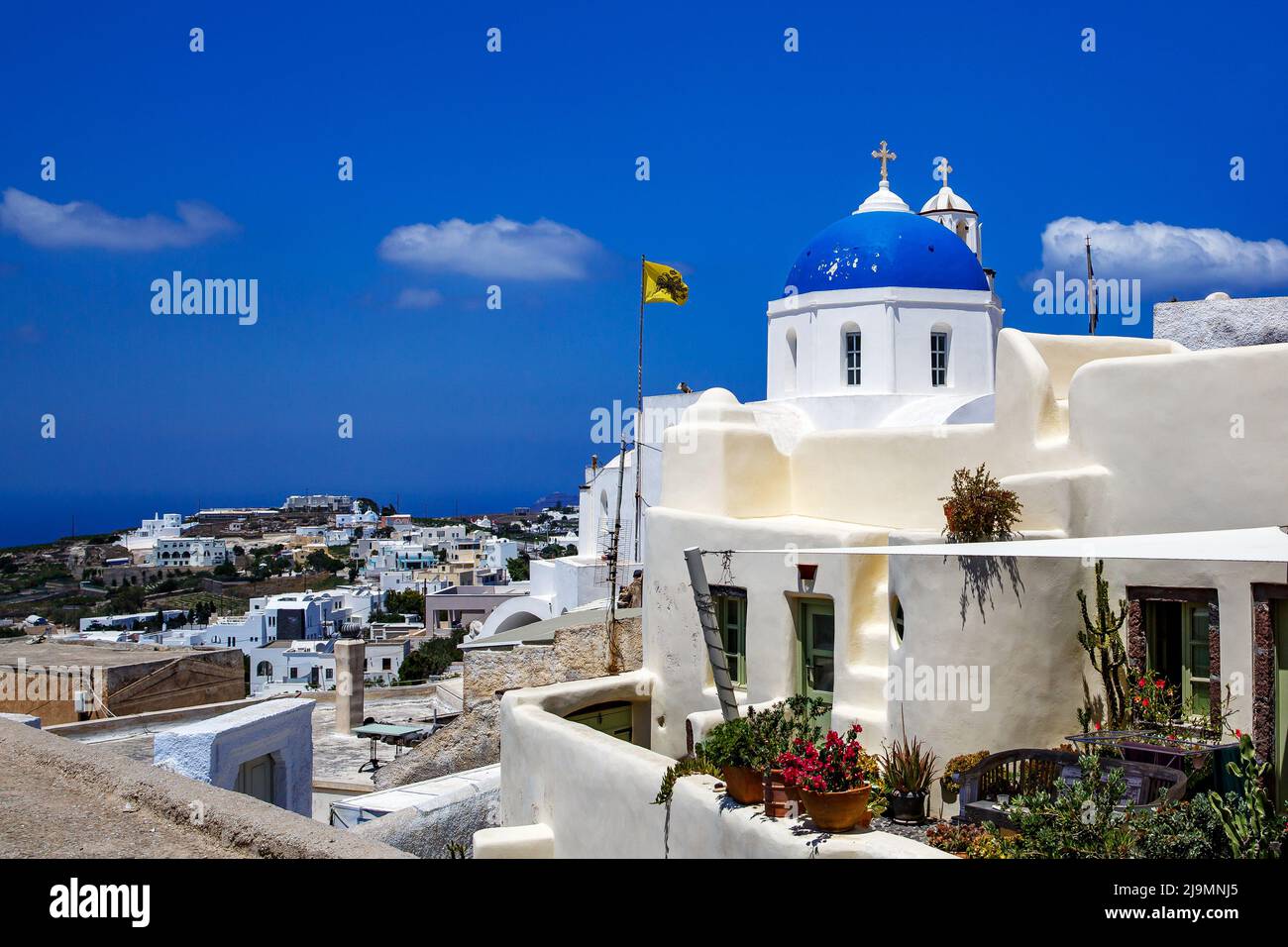 Église blanche avec un dôme bleu sur l'île de Santorini en Grèce. Soleil d'été chaud. Banque D'Images