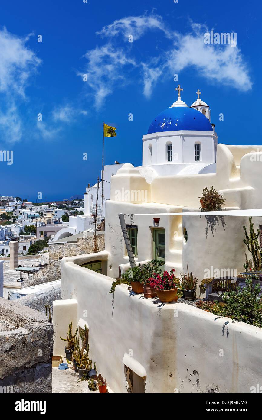 Église blanche avec un dôme bleu sur l'île de Santorini en Grèce. Soleil d'été chaud. Banque D'Images
