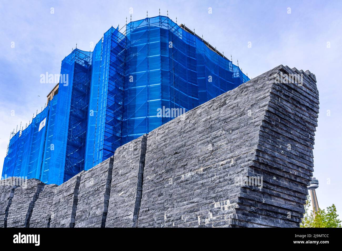 Revitalisation du Canada Malting Silos (recouvert de tissu bleu). Le lieu du patrimoine est encadré par une sculpture en pierre dans le parc Ireland. Banque D'Images
