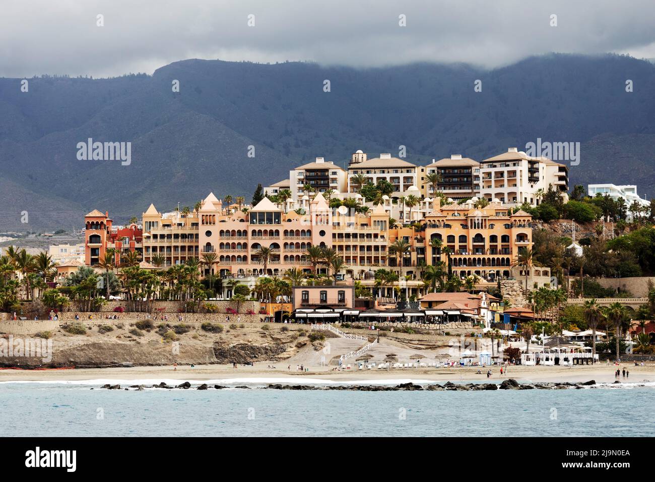 Chaises longues, vacanciers et hôtels sur la Costa Adeje à Ténérife, Espagne. La région est une destination de vacances populaire. Banque D'Images
