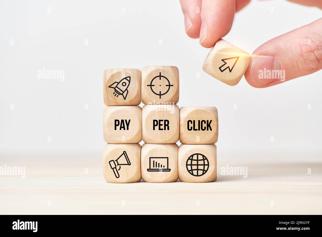 Paiement par clic ou PPC. La personne empile des cubes en bois à partir de texte et d'icônes Banque D'Images