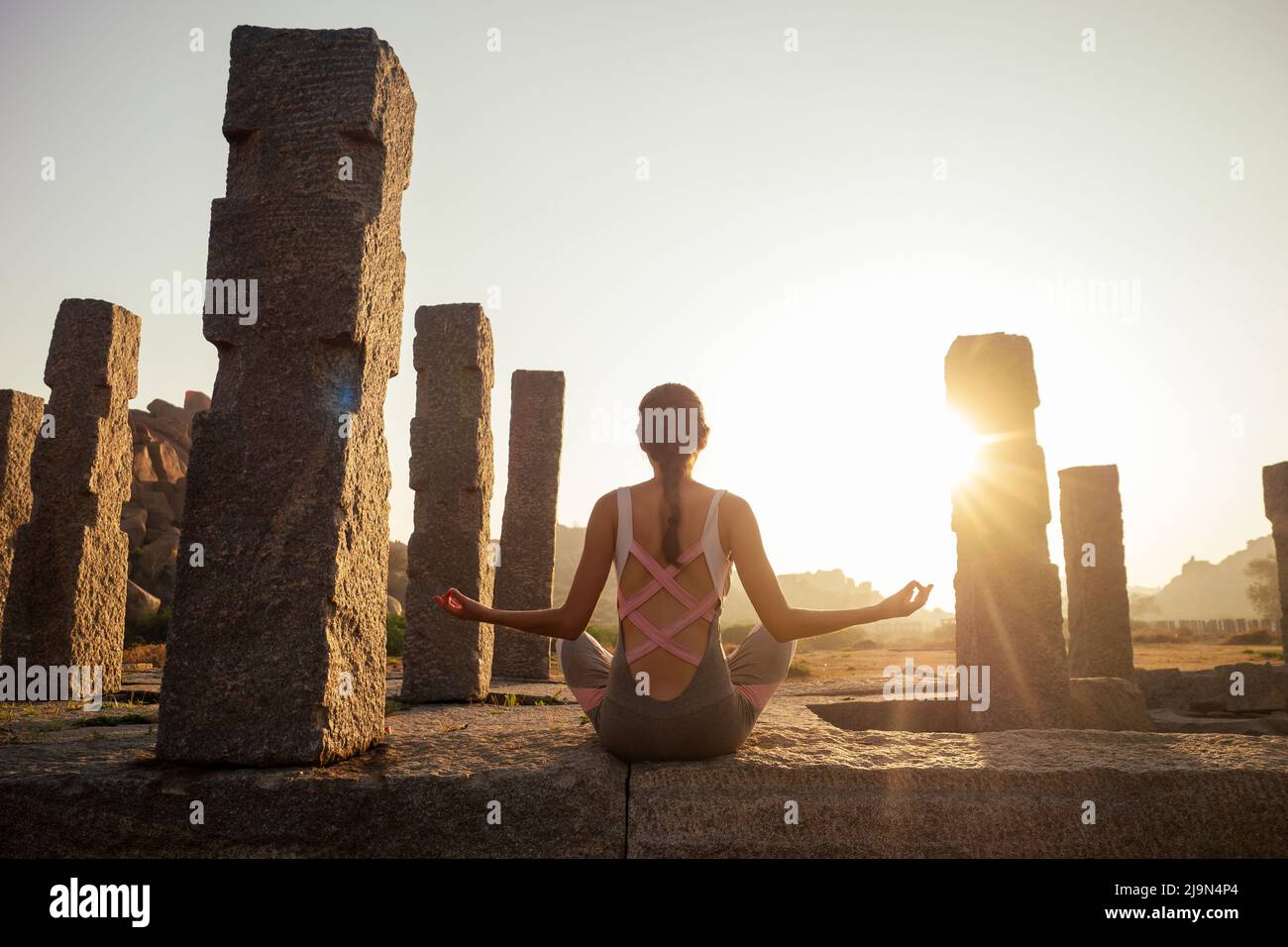 Yoga dans Hampi temple copyspase au coucher du soleil.voyage copie de vacances spase dame avec jumpsuit élégant Banque D'Images