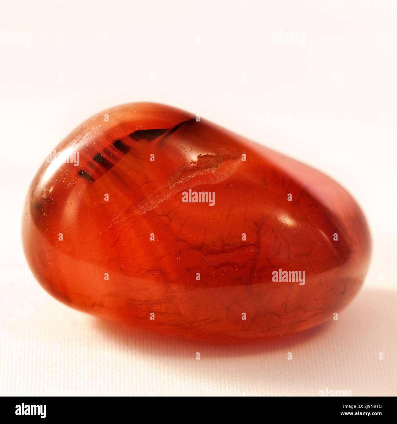 Macro gros plan photo en couleur d'une « agate rouge » polie une pierre précieuse en cristal semi-précieuse utilisée dans la thérapie de guérison en cristal Banque D'Images