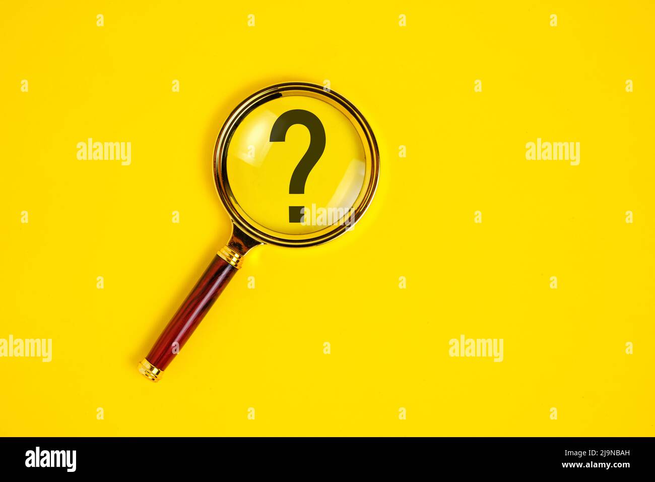 Point d'interrogation sous la loupe, sur fond jaune Banque D'Images