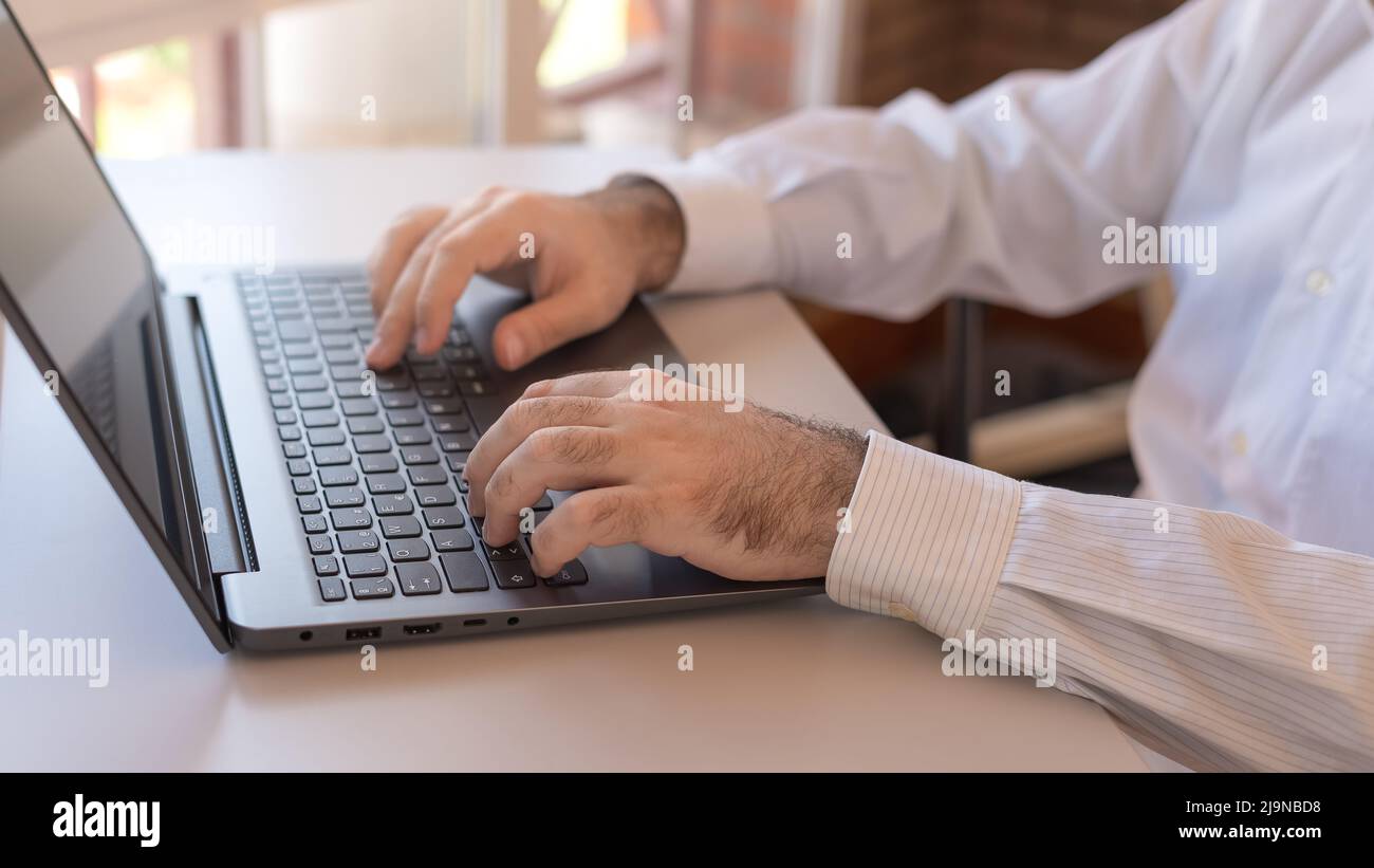 Homme dactylographiant sur un ordinateur portable, télétravailleur à la maison. Banque D'Images