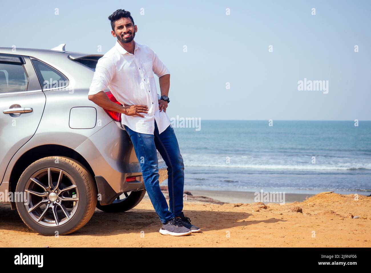 Voyage vacances heureux indien dans blanc chemise collier acheter nouvelle voiture et montrant la clé, assis en voiture sur la plage mer inde octan Goa. Un voyage à la Banque D'Images