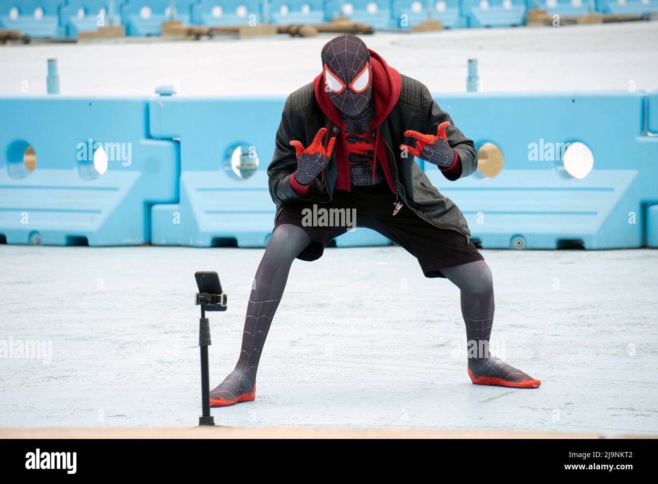 À l'aide d'un trépied, Spiderman prend quelques selfies sous le Unisphere à Flushing Meadows Corona Park à queens, New York. Banque D'Images