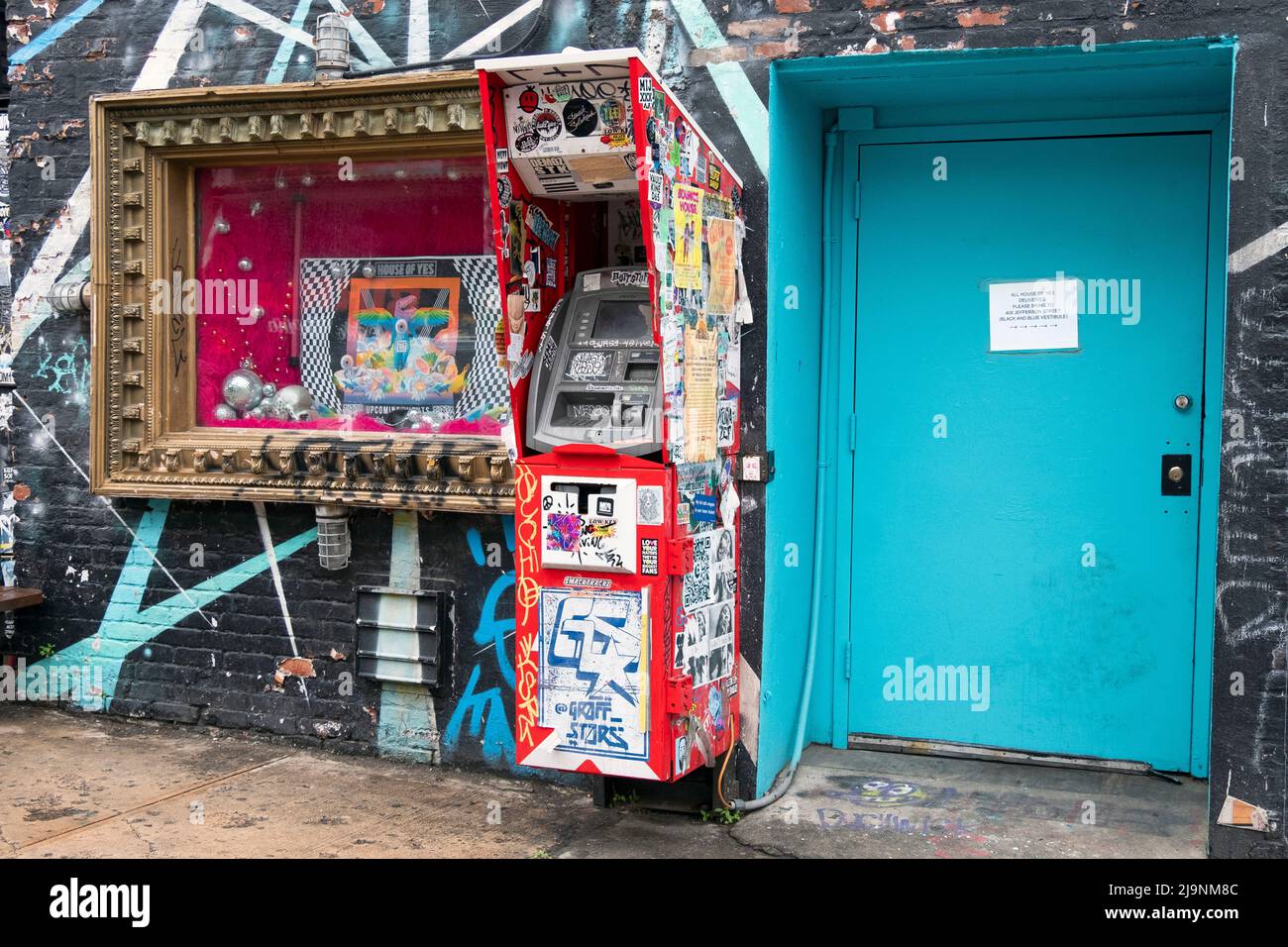 Un collage d'autocollants, d'étiquettes, d'avis et de graffitis sur un guichet automatique extérieur situé sur Wycoff Avenue à Bushwick, Brooklyn, le capitole de l'art extérieur de New York. Banque D'Images