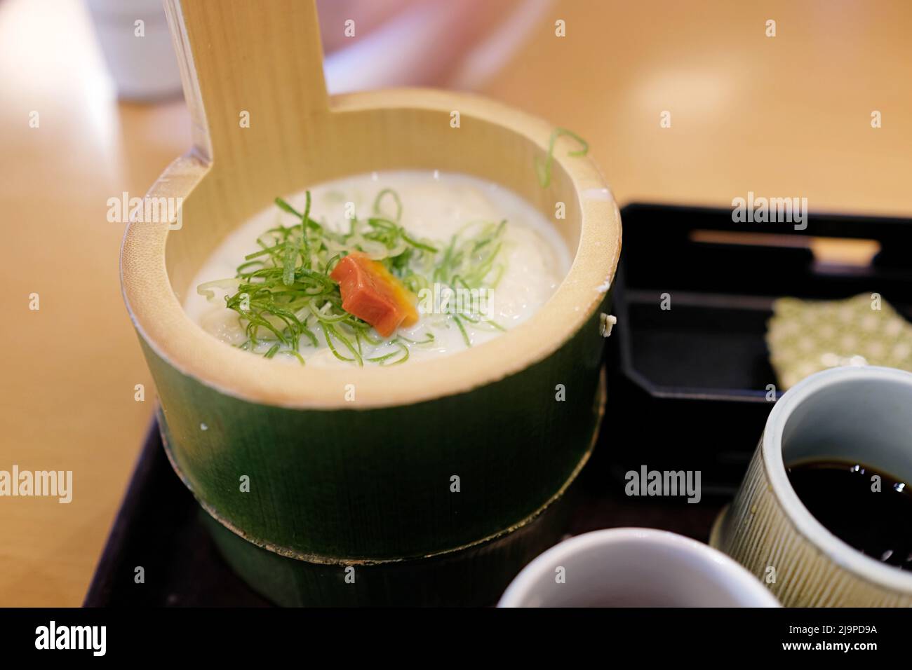 Un traditionnel lait de soja de style Kyoto et tofu chaud servi dans un bol de bambou (cuisine de Kansai) - Arashiyama, Kyoto, Japon. Banque D'Images