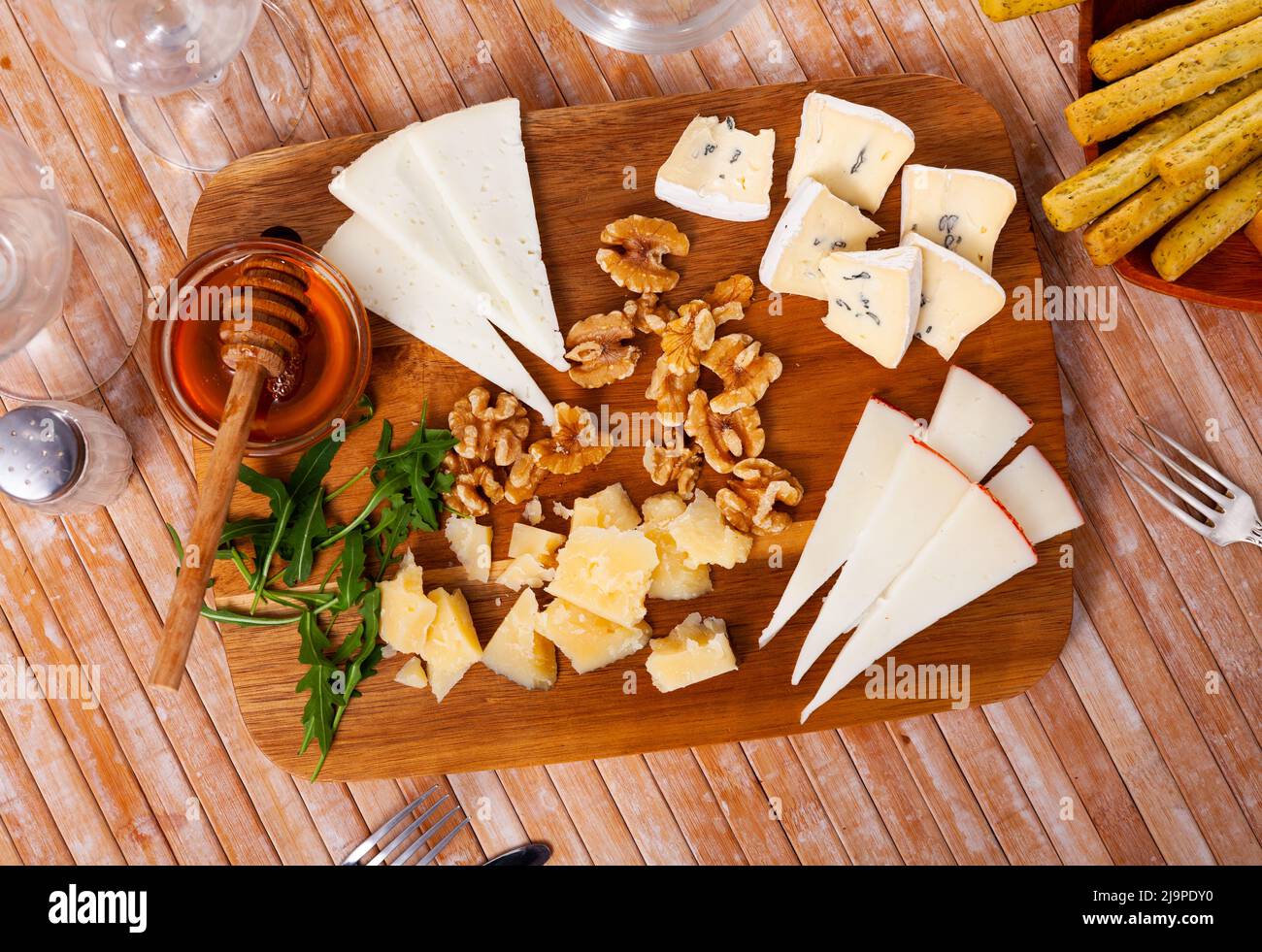 Différents types de fromage servis sur bois avec du miel, des tranches de noix Banque D'Images