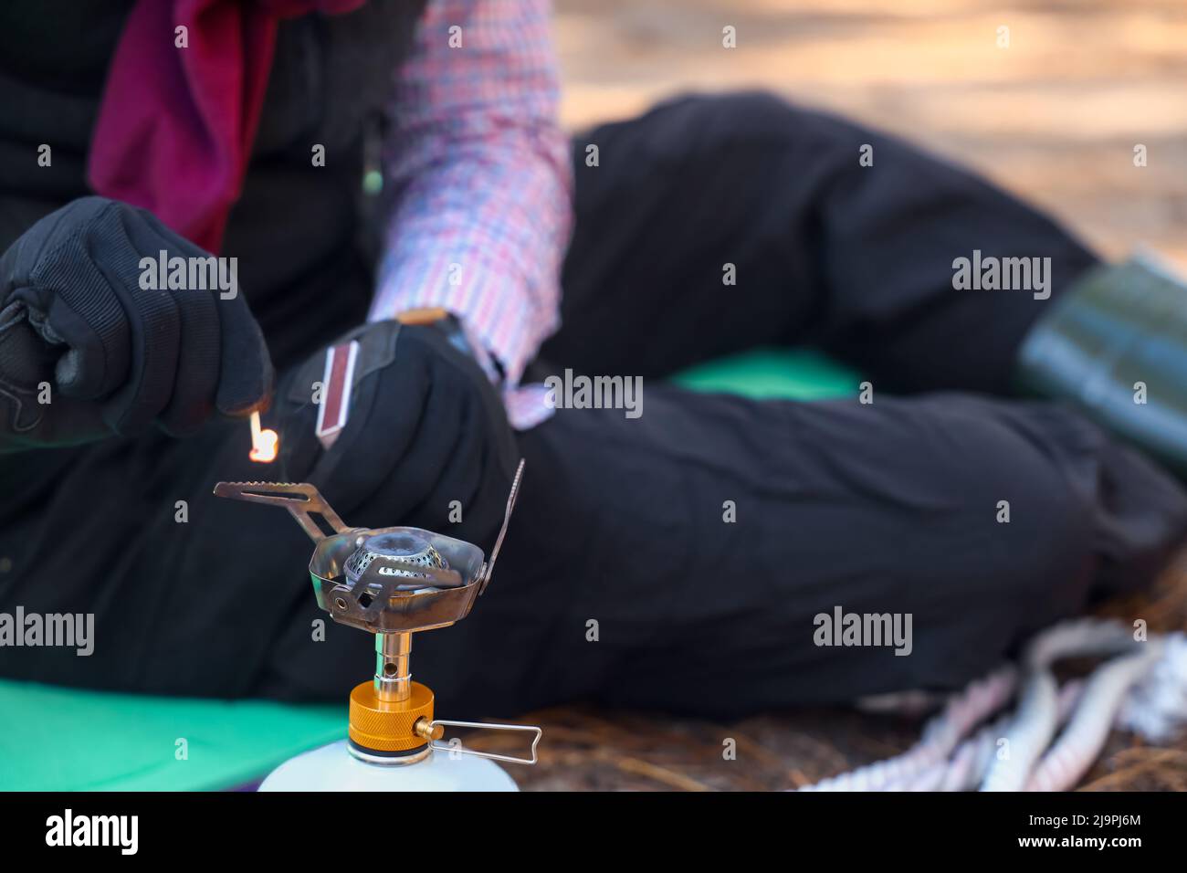 Touriste mâle avec brûleur à gaz portable et allumettes en forêt, en gros plan Banque D'Images