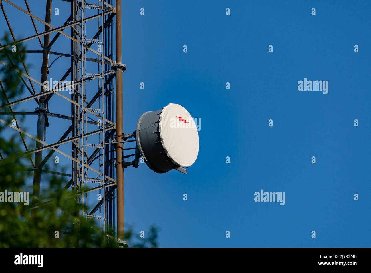 Antenne parabolique ronde montée sur une structure d'antenne plus grande contre Blue Sky Banque D'Images