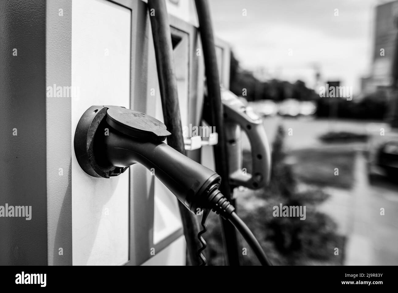 Détails de faible profondeur de champ (mise au point sélective) avec prise électrique ou prise électrique automatique au niveau d'une station de charge de véhicule électrique. Banque D'Images