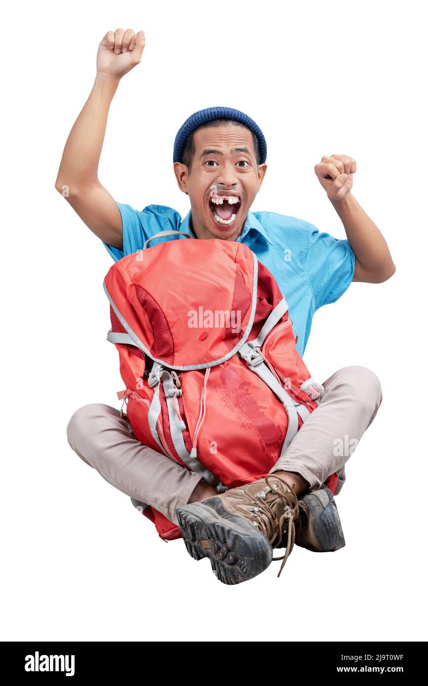 Homme asiatique avec un bonnet beanie assis avec son sac à dos isolé sur fond blanc Banque D'Images