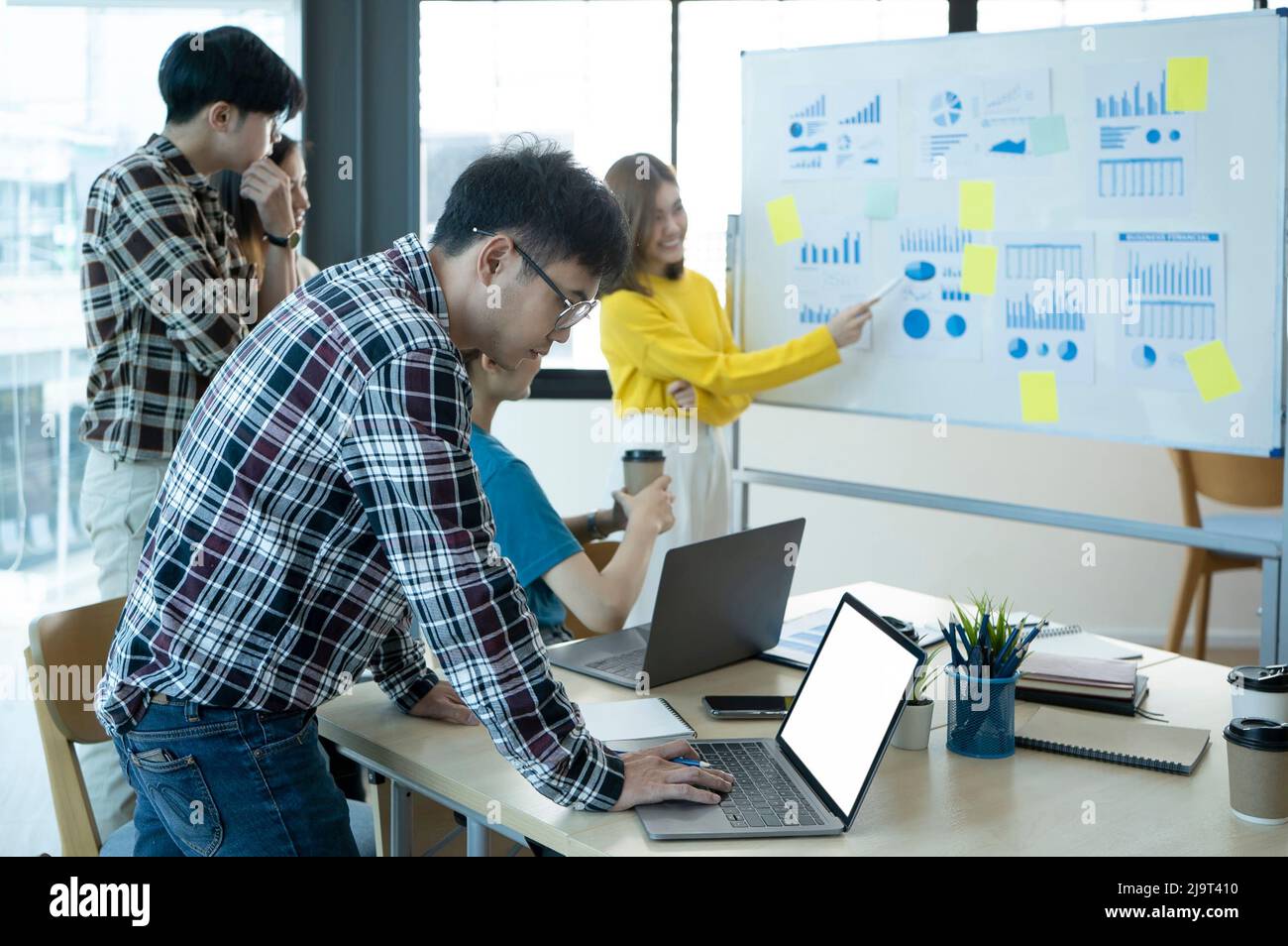 Équipe de jeunes entreprises travaillant sur leur projet de démarrage ensemble dans un bureau moderne lumineux. Banque D'Images