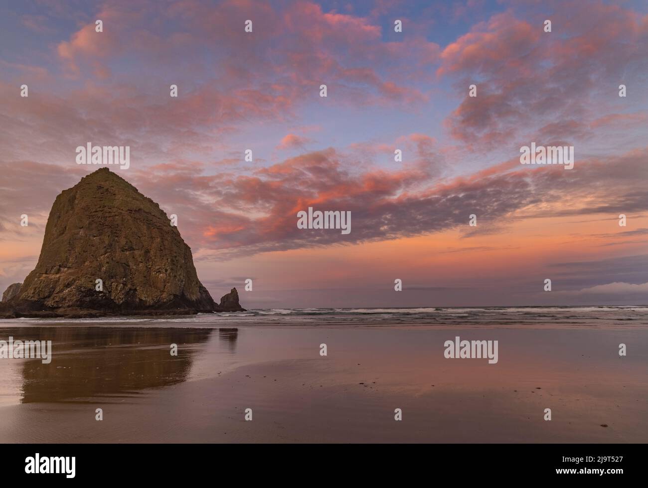 Le lever du soleil se fait au-dessus de Haystack Rock à Cannon Beach, Oregon, États-Unis Banque D'Images