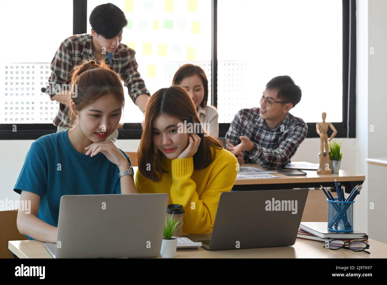 Équipe de démarrage travaillant ensemble au bureau lumineux avec des appareils modernes. Banque D'Images