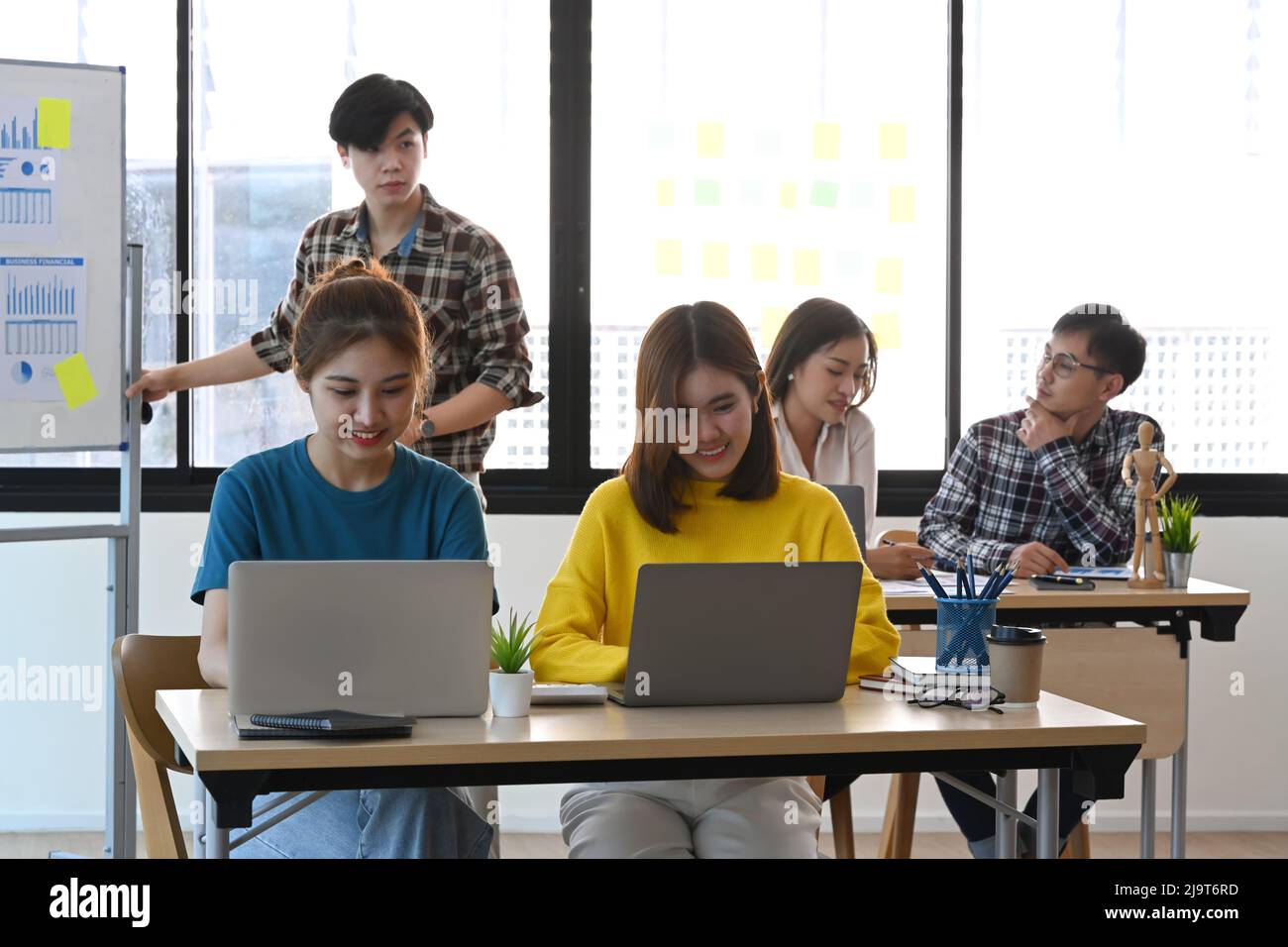 Démarrage de professionnels travaillant ensemble dans un bureau lumineux avec des appareils modernes. Banque D'Images