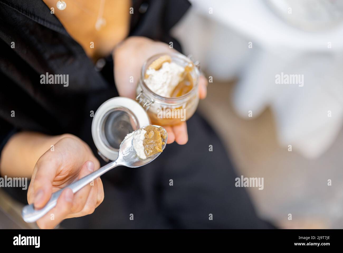 Femme mangeant un dessert tiramisu au restaurant à l'extérieur Banque D'Images