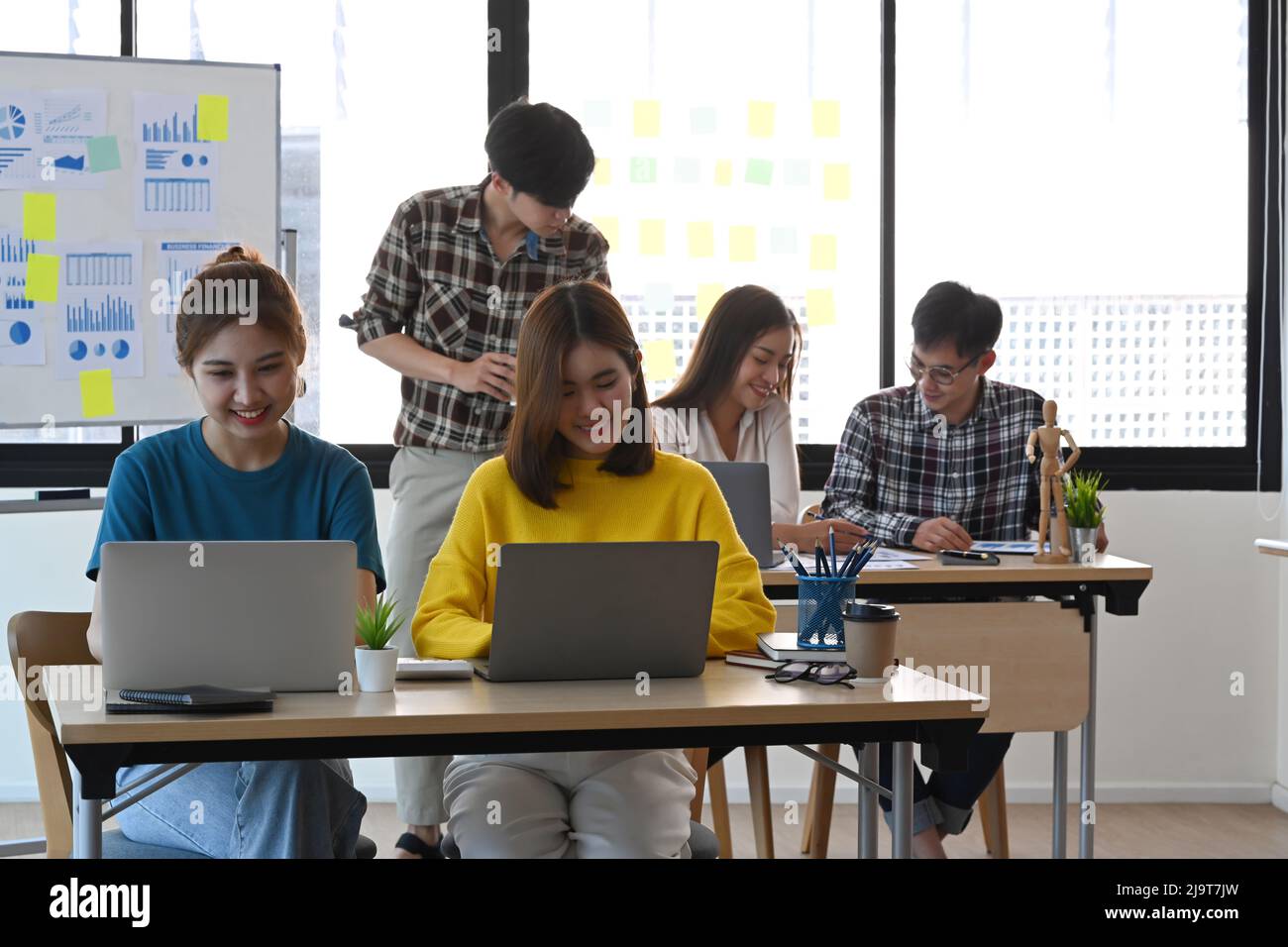 Un groupe de jeunes gens d'affaires travaillent ensemble dans un bureau moderne et lumineux. Banque D'Images